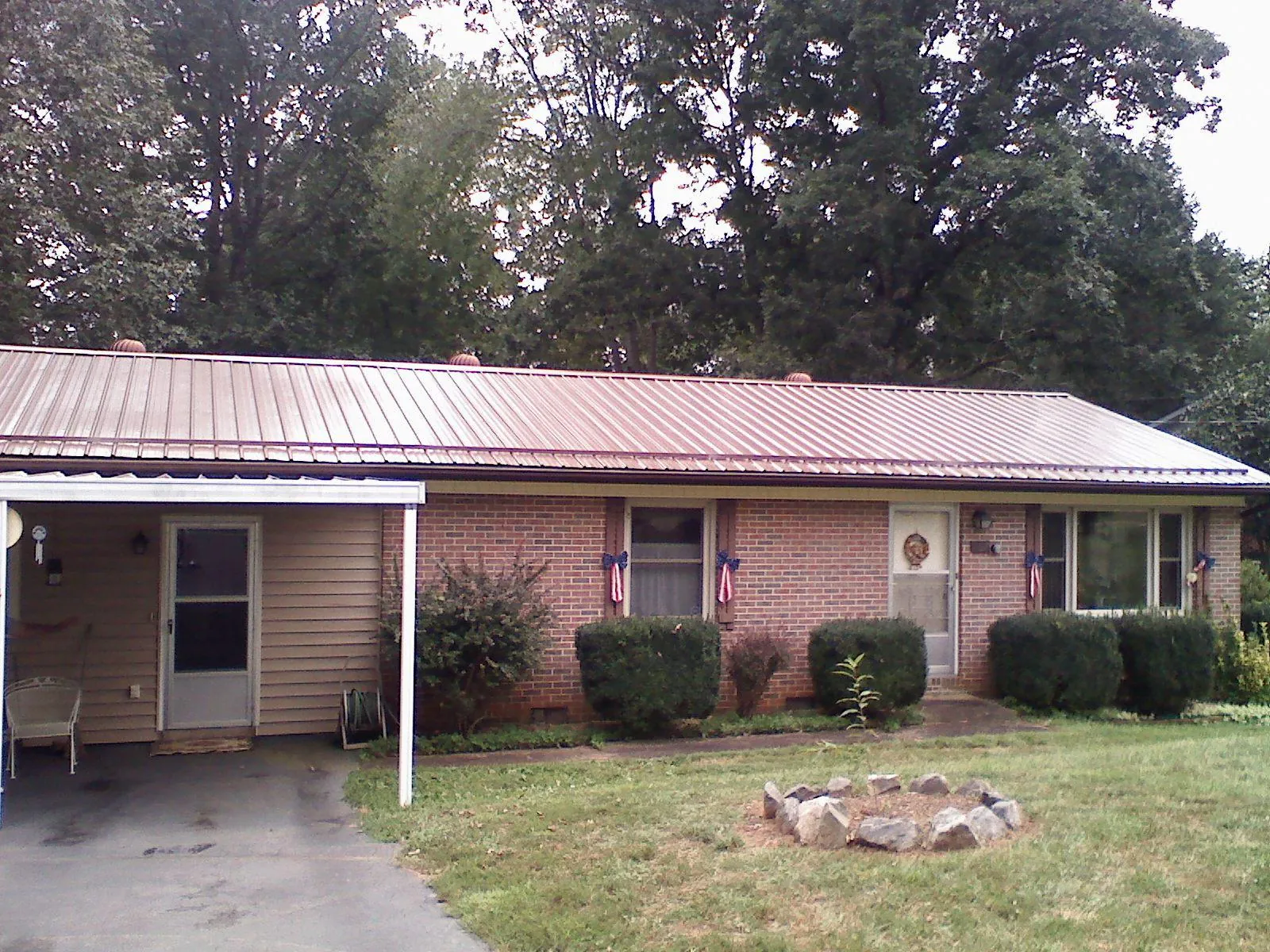 Bronze metal roof and carport on a brick ranch home — Roof Repair work by our crew in Polk City